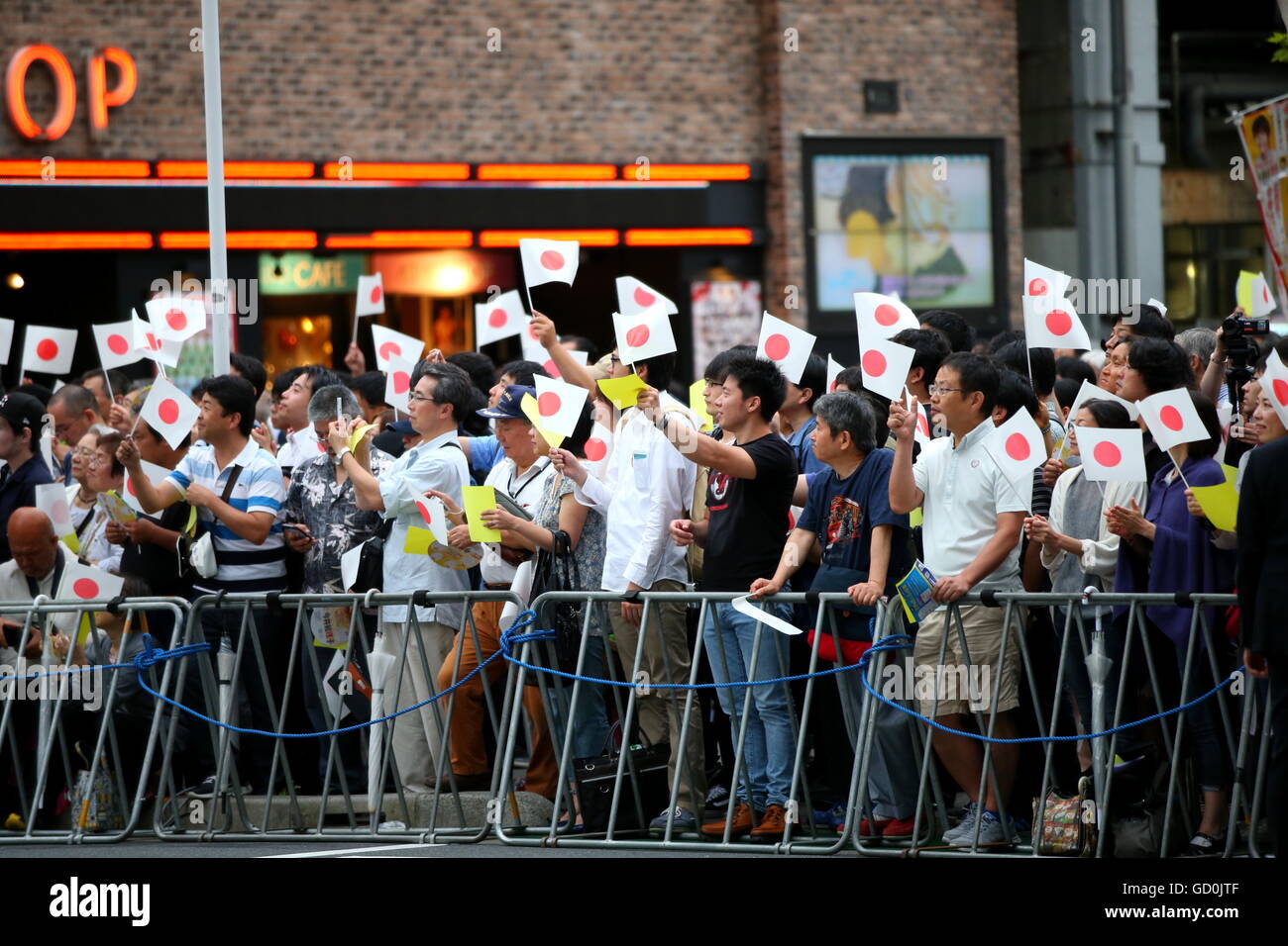 People wave Japanese national flags as Japanese Prime Minister and ...