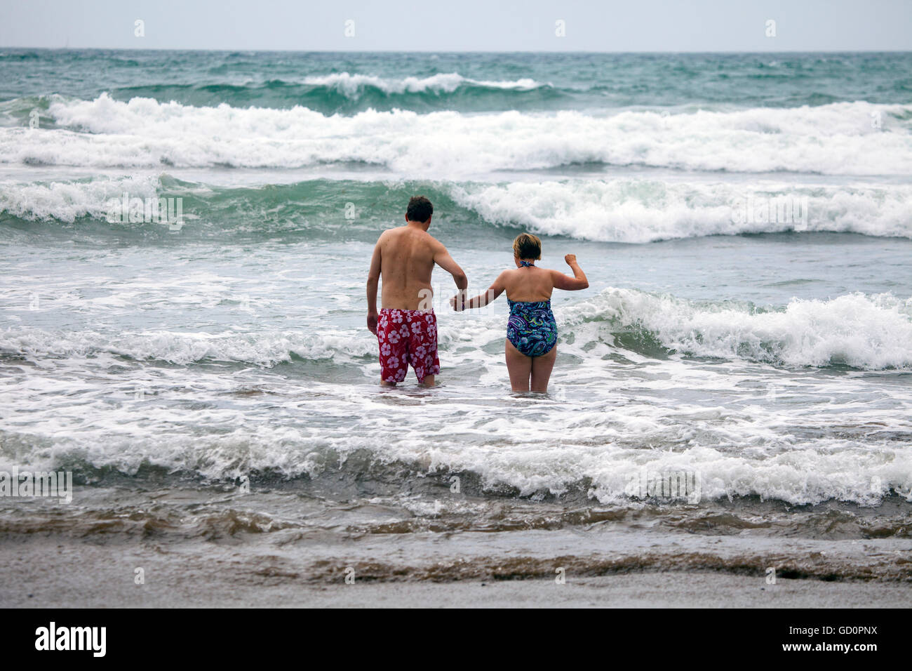 Surfer couple holding hands hi-res stock photography and images - Alamy