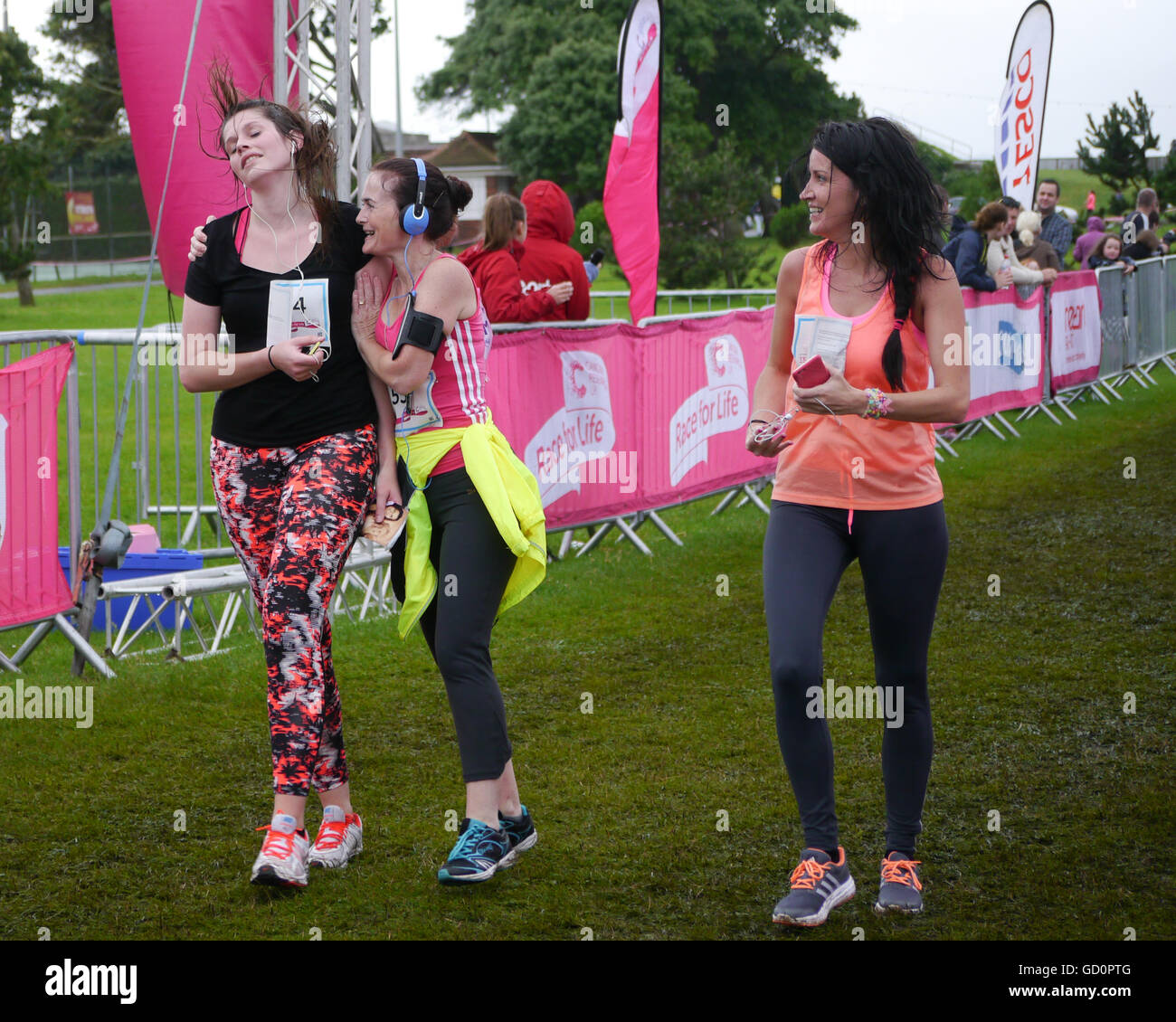 Portsmouth, Hampshire, UK. 10 July 2016. Friends cross the finish line at the end of the Race for life. The Race for life is a charity event in which females complete a 10Km or 5Km run in aid of cancer research. Credit:  simon evans/Alamy Live News Stock Photo