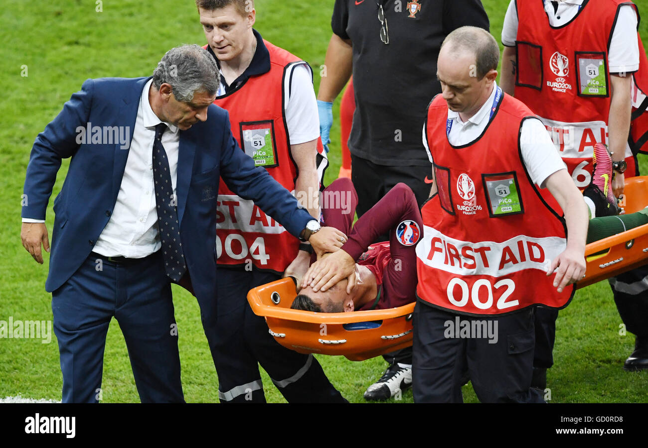 Saint-Denis, France. 10th July, 2016. Portugal's coach Fernando Santos (l) comforts Cristiano Ronaldo of Portugal who is being carried off the pitch after he received an injury during the UEFA EURO 2016 soccer Final match between Portugal and France at the Stade de France, Saint-Denis, France, 10 July 2016. Photo: Peter Kneffel/dpa Credit:  dpa picture alliance/Alamy Live News Stock Photo