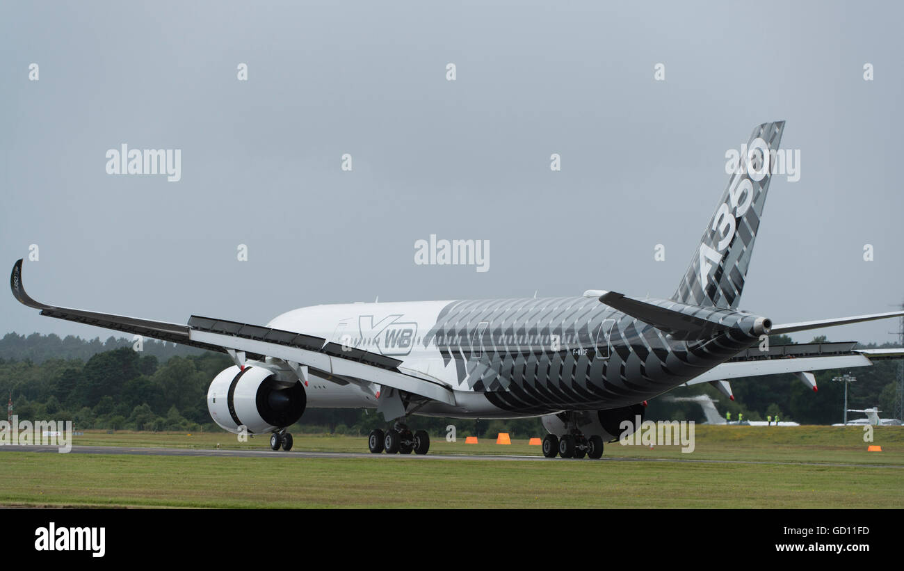 Farnborough, Hampshire UK. 11th July 2016. Airbus A350 flying debut under darkening skies. Opening day of the Farnborough International Trade Airshow where major international aviation and aerospace business is signed off. The Trade Show runs from 11-15 July and encompasses Civil, Business and Defence Aviation, Space, Rotary Wing and Manufacturing. The Public Airshow runs from 16-17 July. Credit:  aviationimages/Alamy Live News. Stock Photo