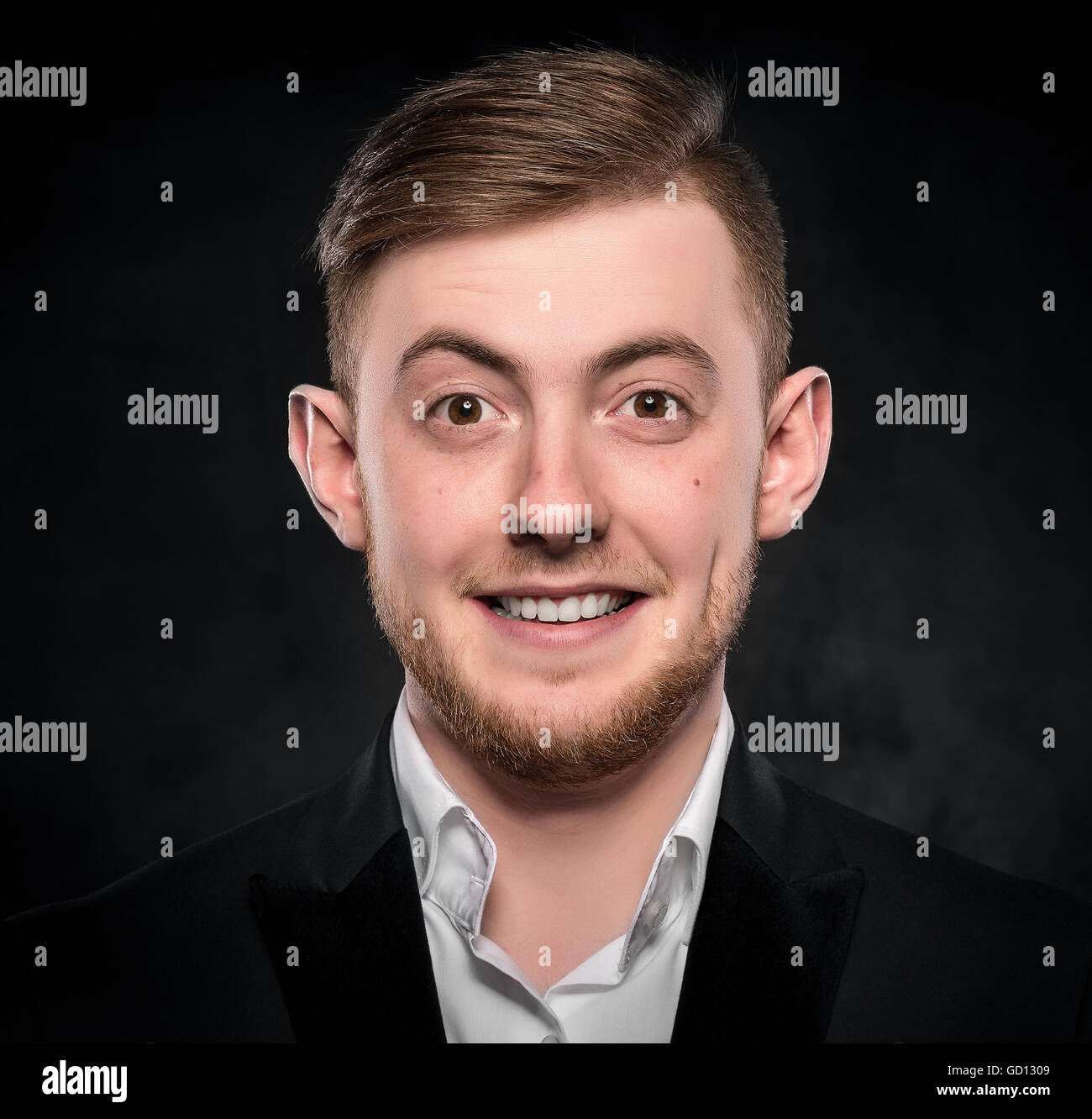 Young handsome man in suit smiling on dark background Stock Photo - Alamy