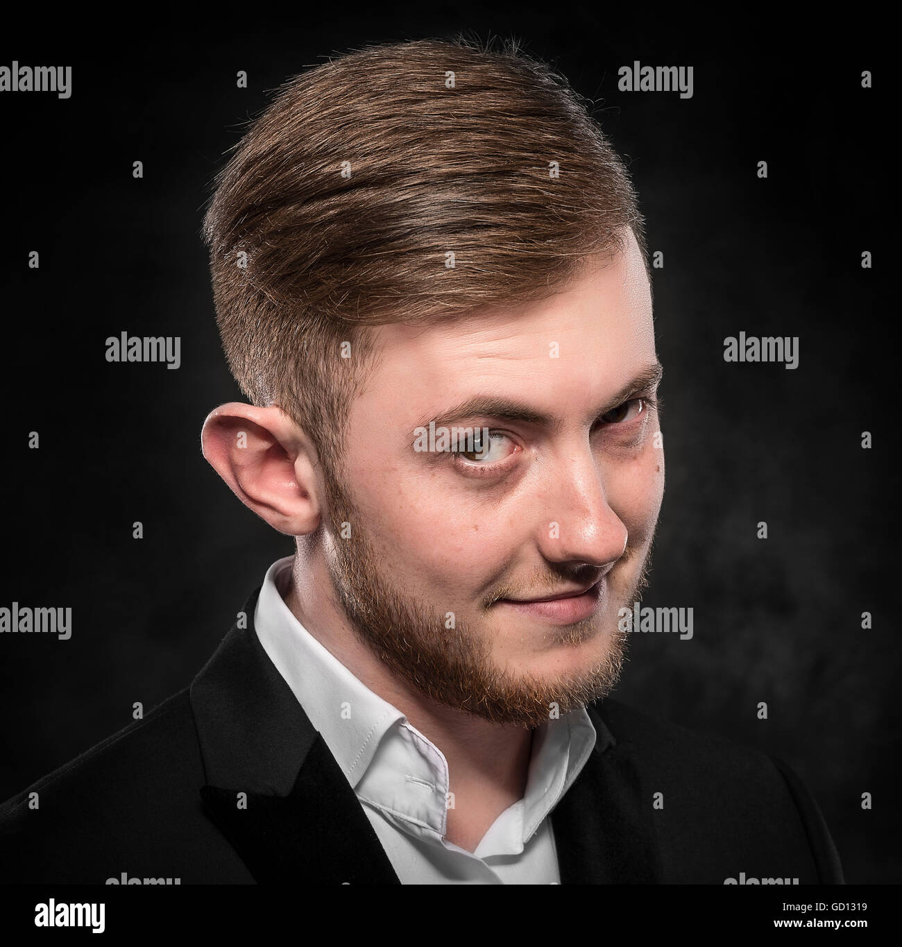 Young handsome funny man in black suit smiling over dark background ...
