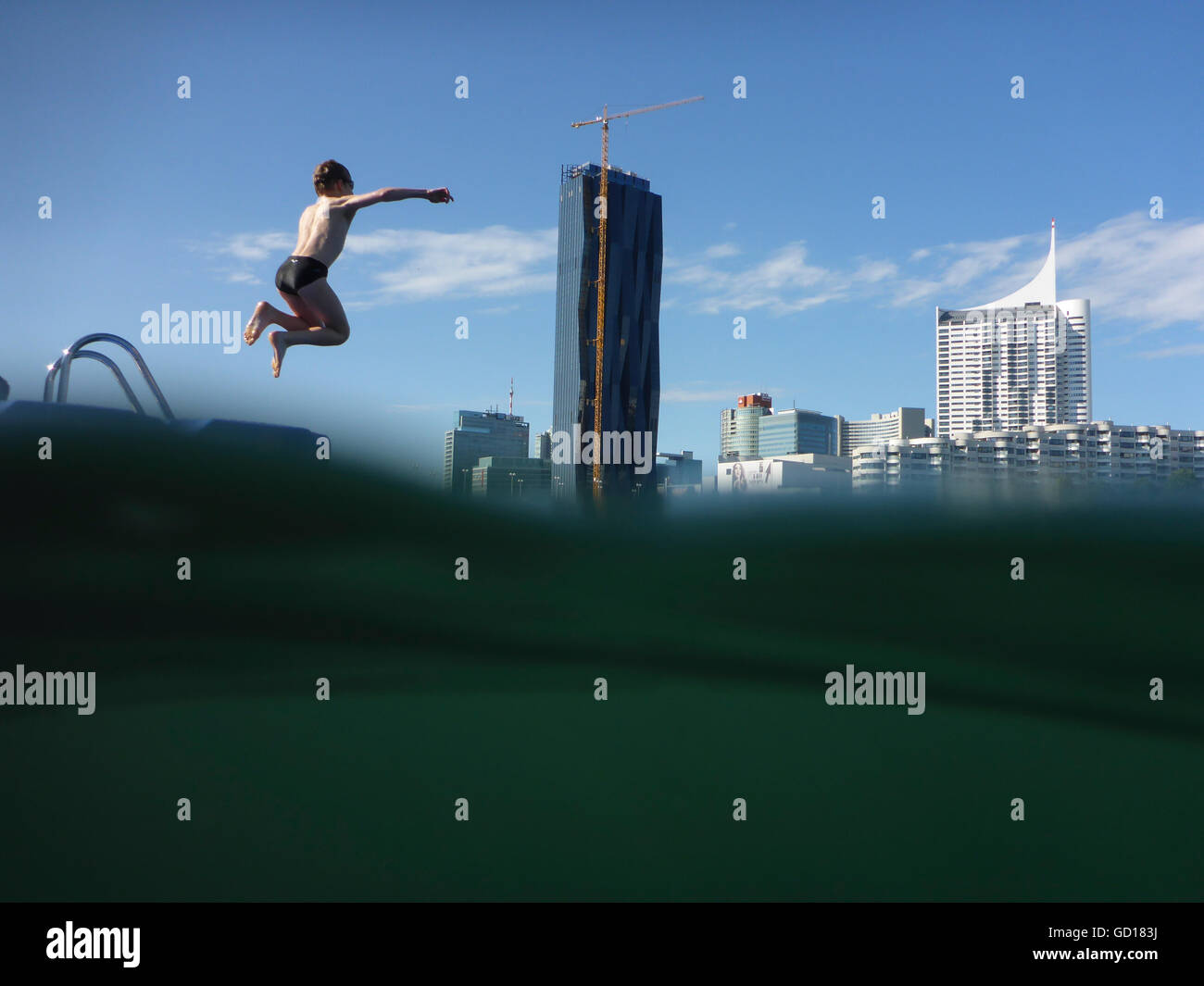 Wien, Vienna: Boy jumps in the New Danube before the DC Tower and the Danube City, Austria, Wien, 22. Stock Photo