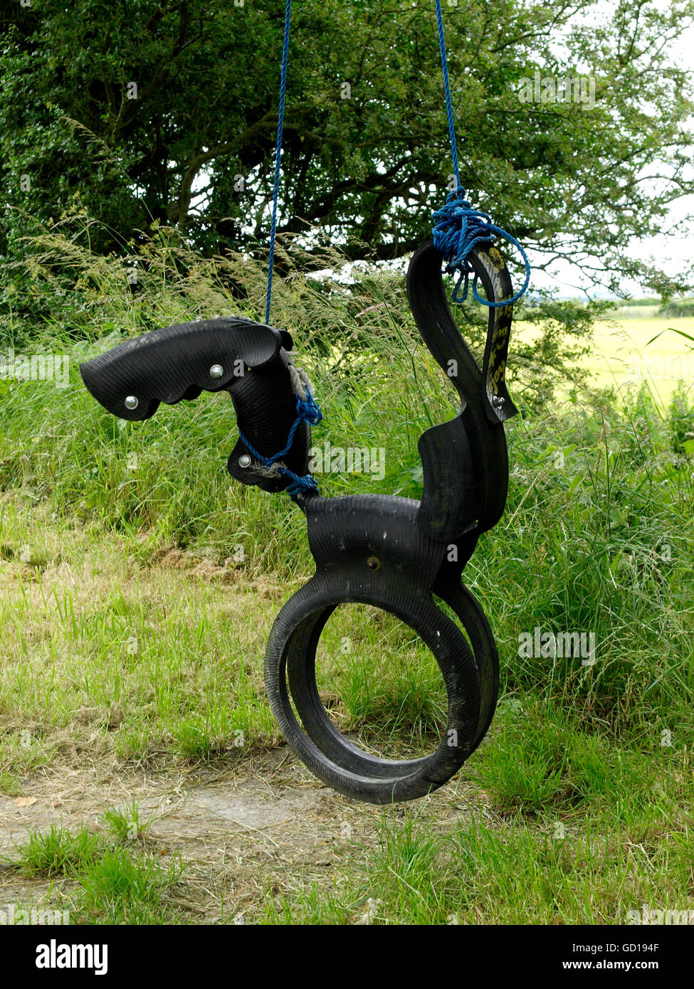 Horse shaped swing made from recycled tires, UK Stock Photo