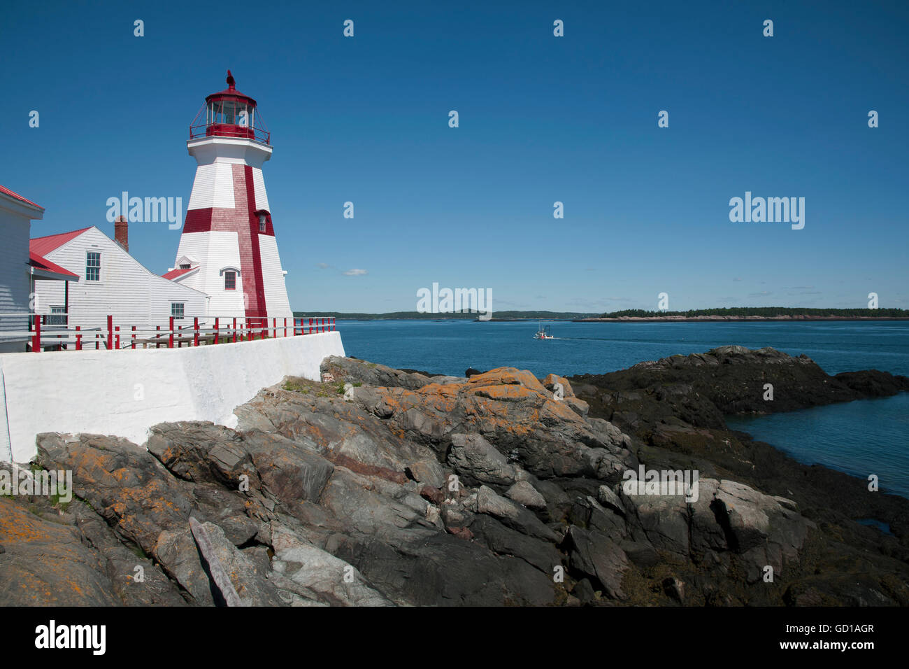 Head Harbor lighthouse, with its unique painted cross, on a sunny day in Canada, guides mariner around the lowest tides on the East Coast. Stock Photo