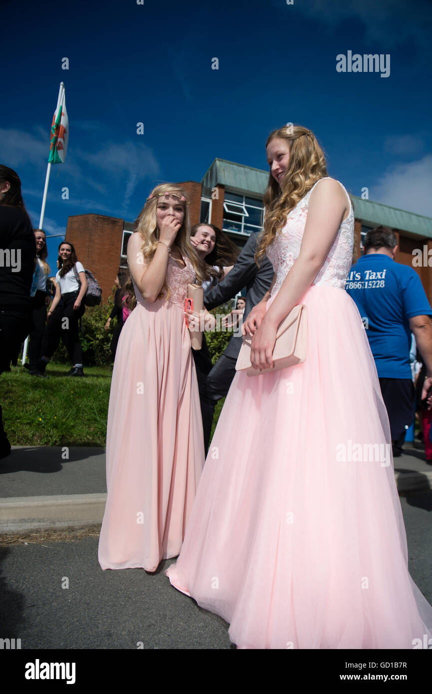 Year 11 teenage girls  at Aberystwyth's Penglais secondary school wearing impressive pink flowing ball-gown style prom dresses to celebrate on their 'leavers day' in  warm sunshine, Wales UK Stock Photo