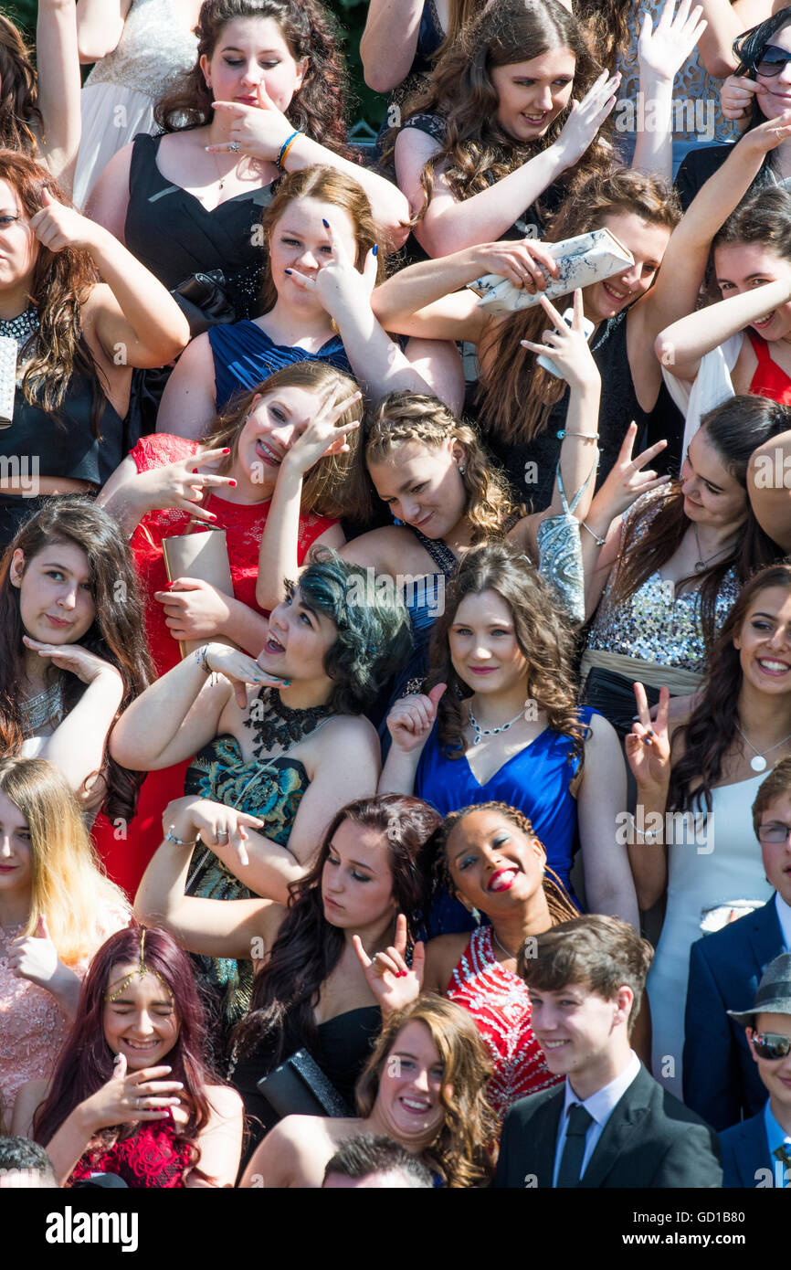 Year 11 teenage girls  at Aberystwyth's Penglais secondary school wearing impressive dresses pose for their  on their 'leavers day' funny group photograph in  warm sunshine, Wales UK Stock Photo