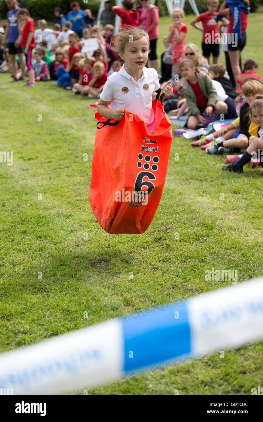 Child competing in sack race St James Primary School sports day Chipping Campden UK Stock Photo