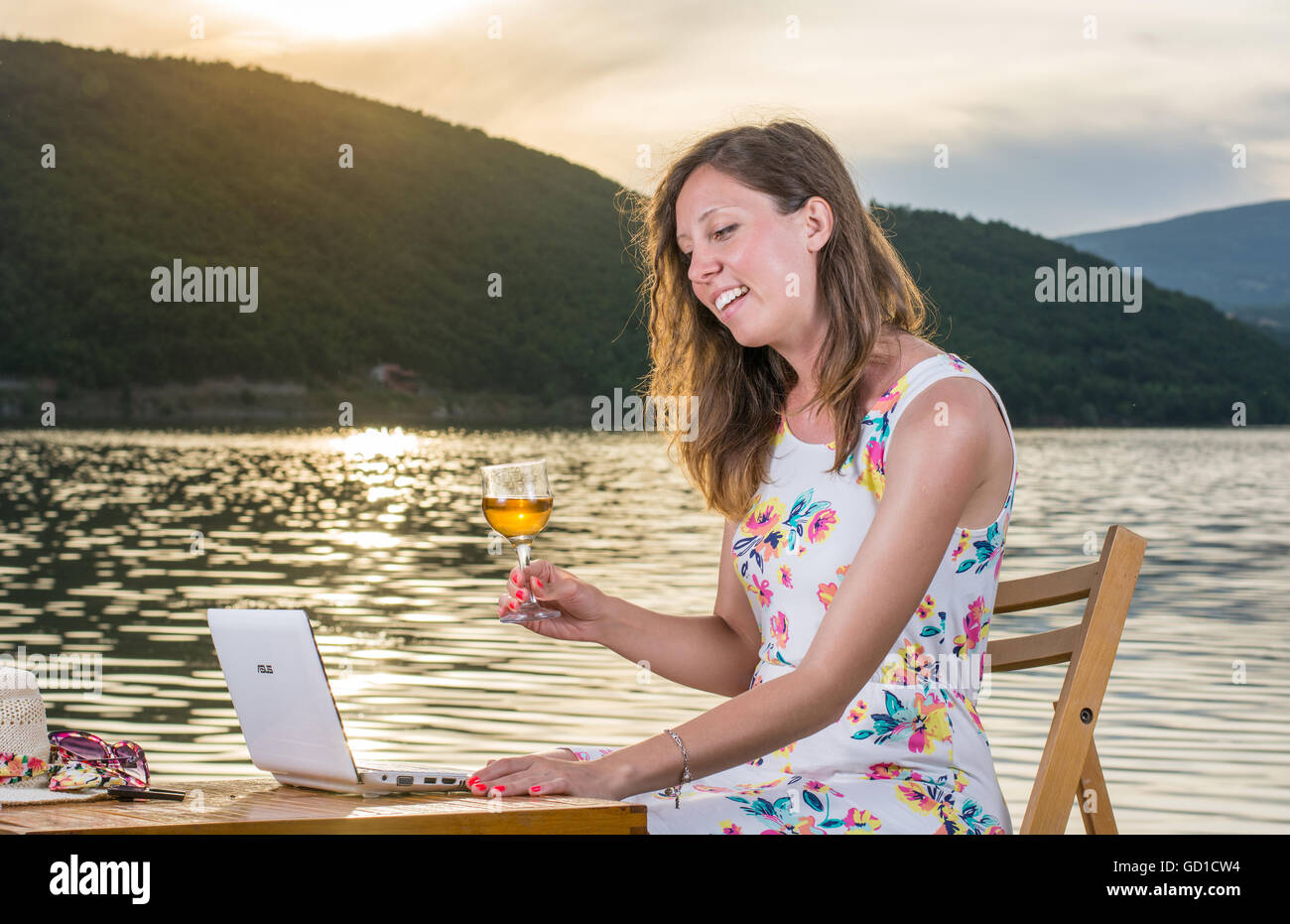 Young woman having a video call by the lake Stock Photo