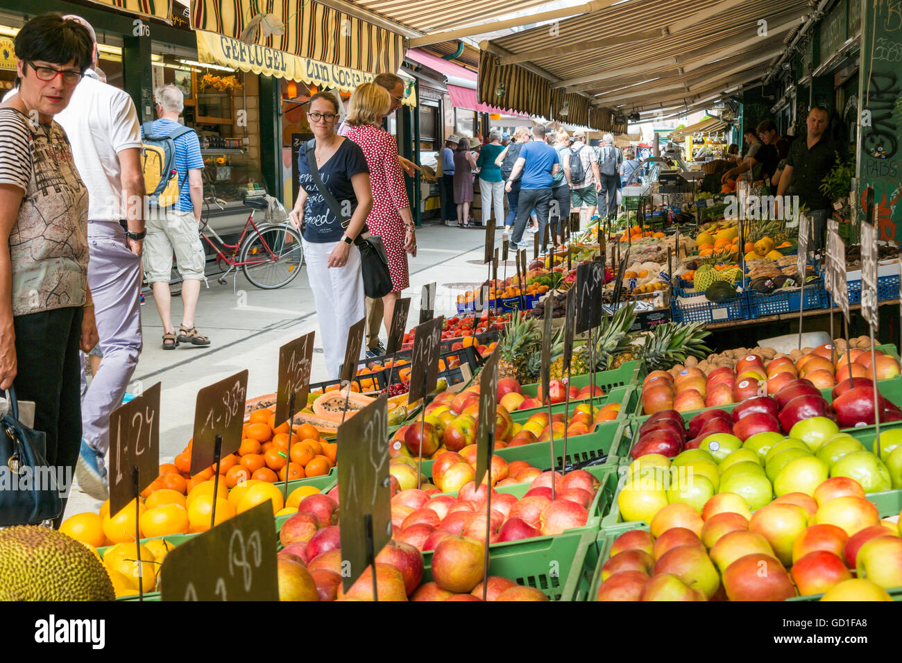 People at fruits and vegetables market stand on Naschmarkt in Vienna, Austria Stock Photo