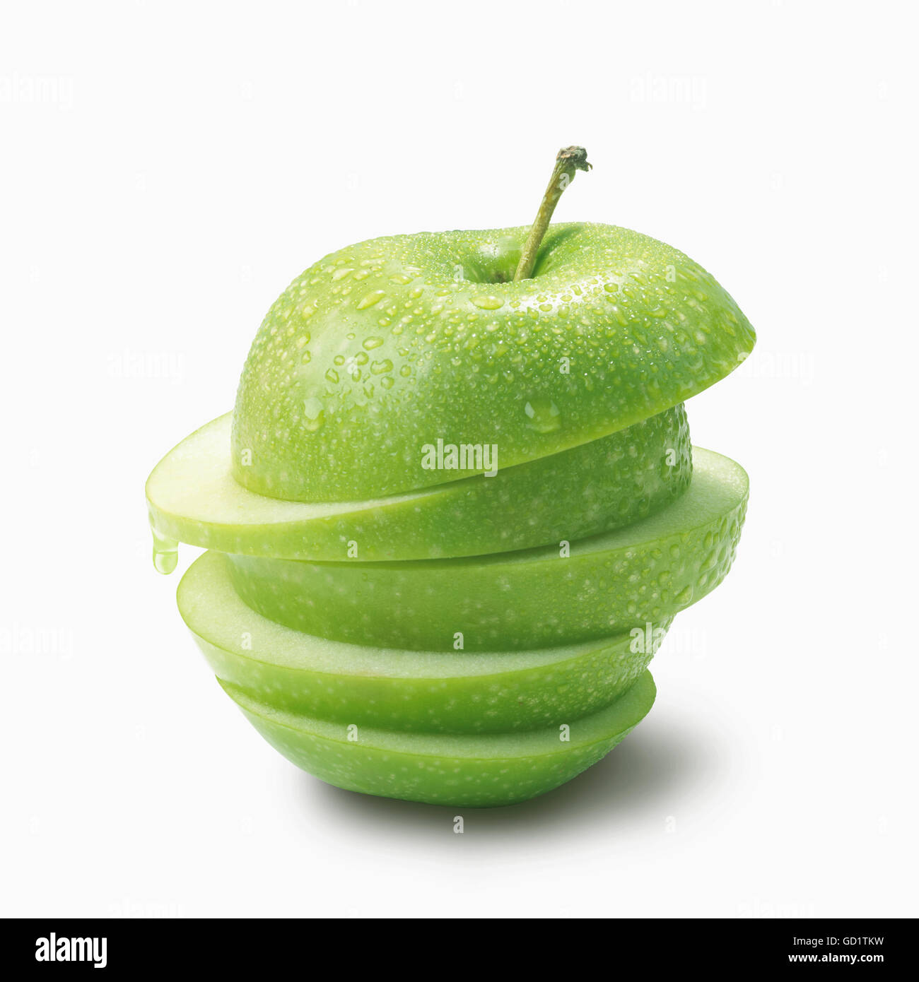 A green apple cut into slices and piled on a white background; Toronto, Ontario, Canada Stock Photo