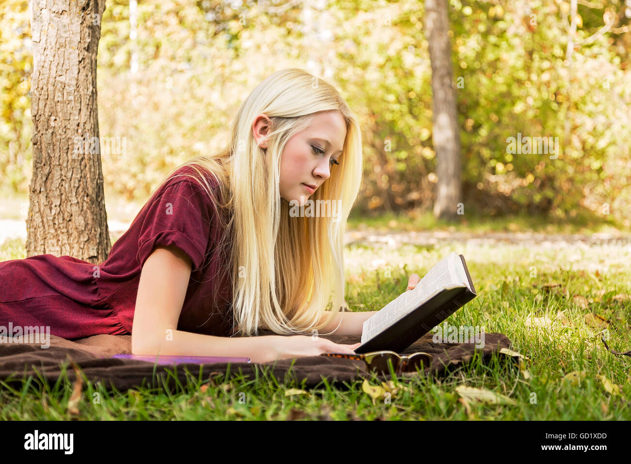 A Young Woman With Long Blond Hair Spending Personal Time In Bible