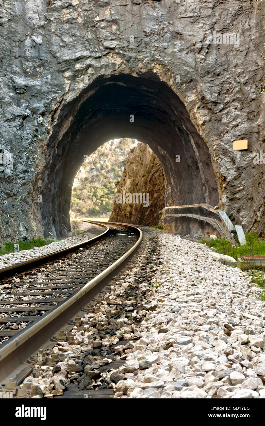 railroad tracks and the tunnel carved in stone entrance in dalmatian hinterland near labin, dalmatia, croatia Stock Photo