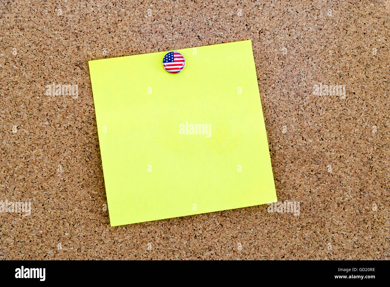 Blank yellow paper note pinned with United States flag thumbtack, copy ...