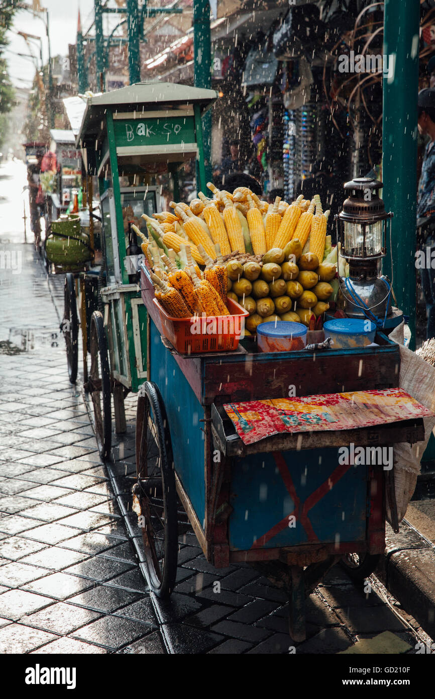 Street food stall with grilled corn under the rain, Ubud, Bali, Indonesia Stock Photo