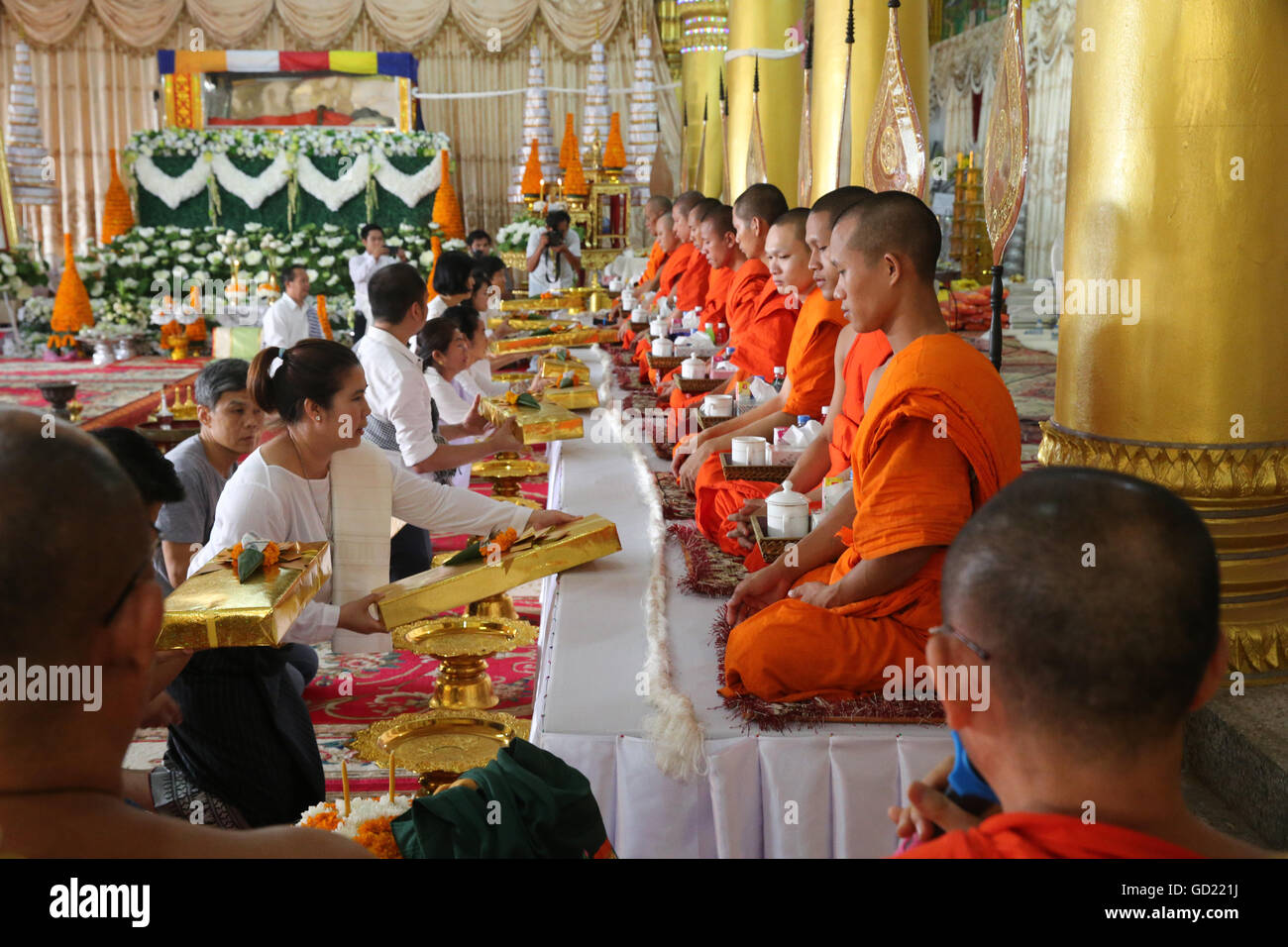 Seated Buddhist monks chanting and reading prayers at a ceremony, Wat