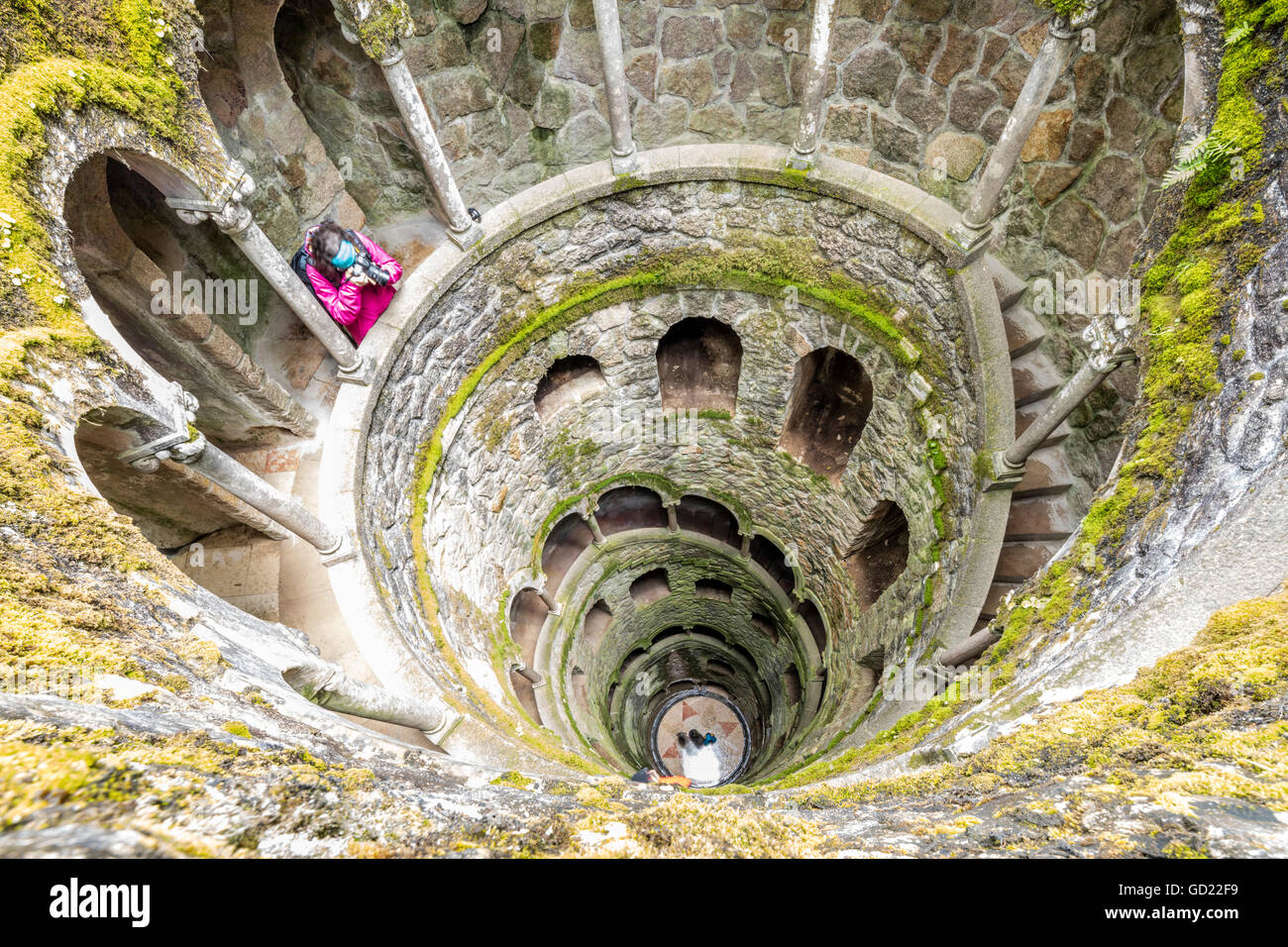 Photographer at the top of the spiral stairs inside the towers of Initiation Well at Quinta da Regaleira, Sintra, Portugal Stock Photo