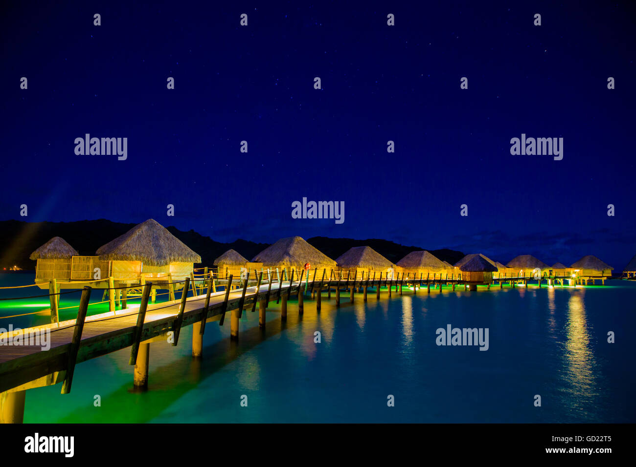 Overwater bungalows at night, Le Taha'a Resort, Tahiti, French Polynesia, South Pacific, Pacific Stock Photo