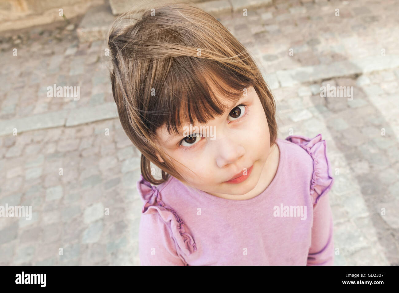 Closeup outdoor portrait of funny cute Caucasian blond baby girl in pink Stock Photo