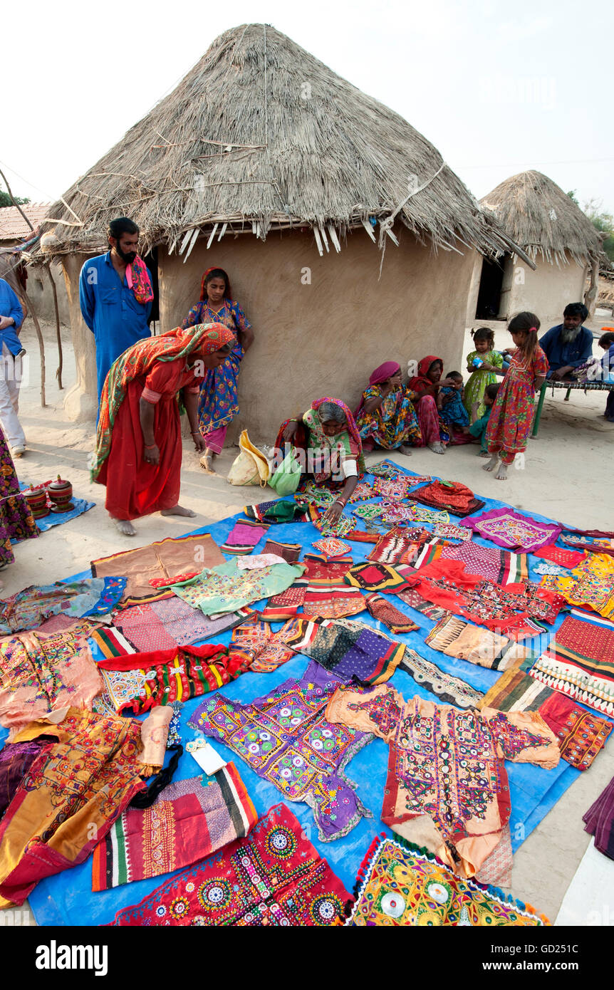 Pathan village women showing their traditional embroideries, mud and thatched tribal houses, Jarawali, Kutch, Gujarat, India Stock Photo