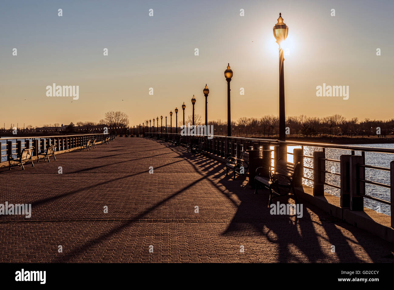 Sun setting behind lampposts, Liberty State Park; Jersey City, New Jersey, United States of America Stock Photo