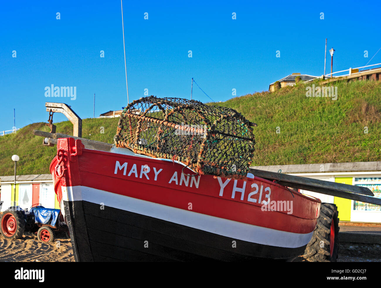 A clinker-built inshore fishing boat with crab-pot on the beach at Cromer, Norfolk, England, United Kingdom. Stock Photo