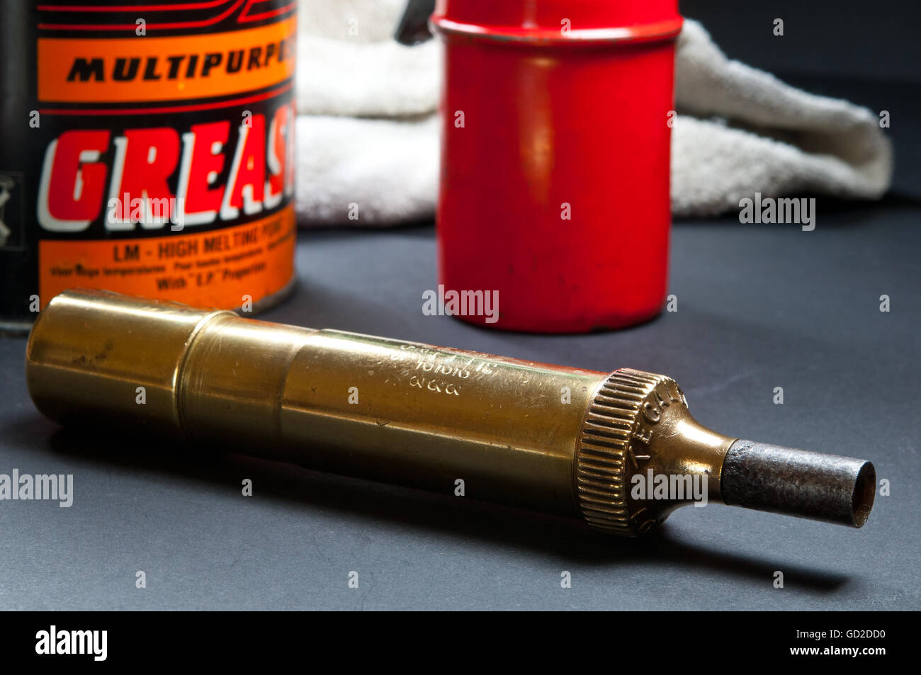 Close up image of vintage Tecalemit brass grease gun and can of grease