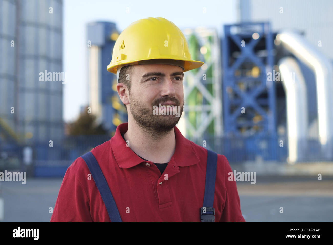 laborer outside a factory working dressed with safety overalls equipment Stock Photo