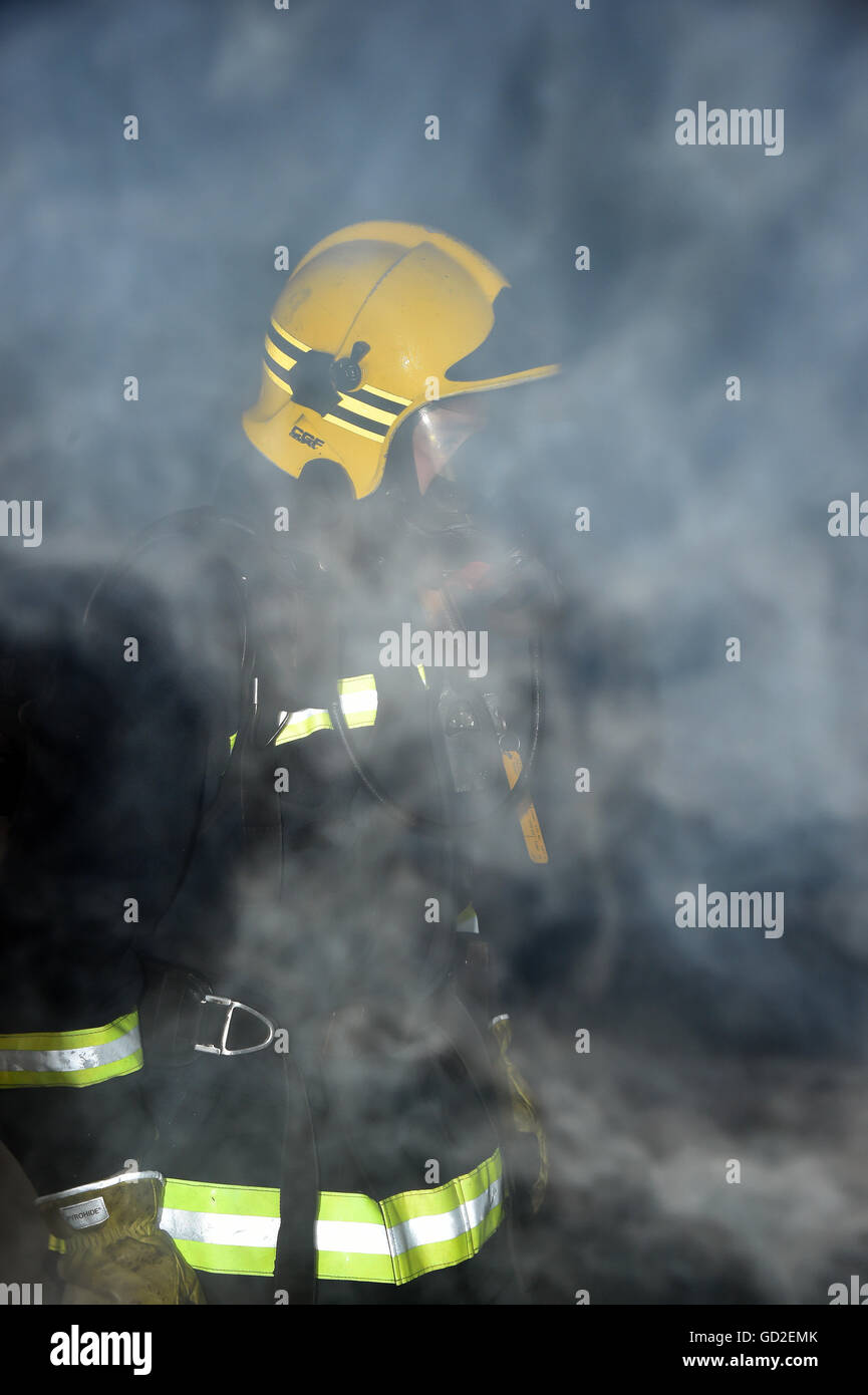 fire service. UK. Great Britain. Firefighter in smoke filled room Stock Photo