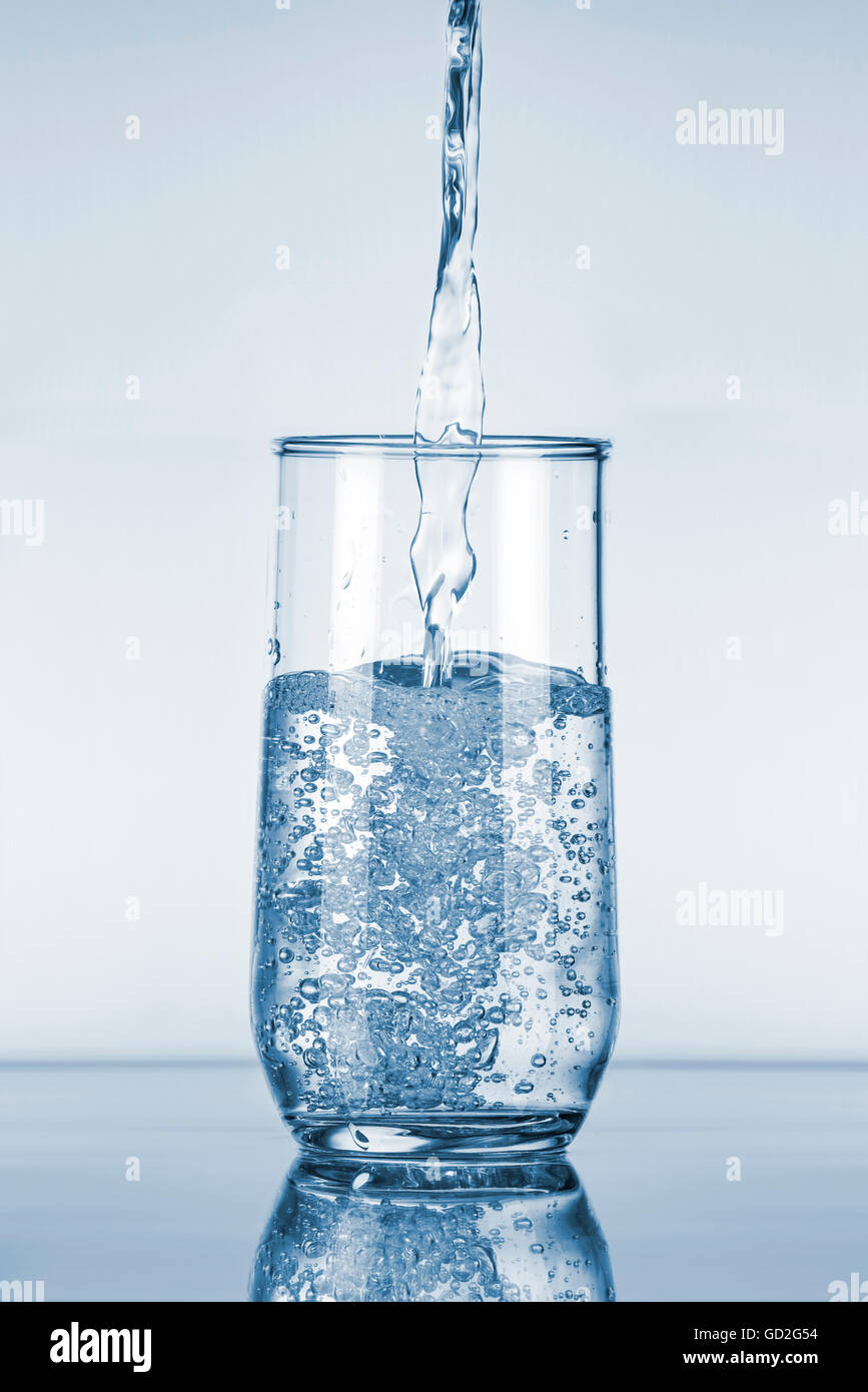 Water Pouring in a Glass over Blue Background Stock Photo Alamy