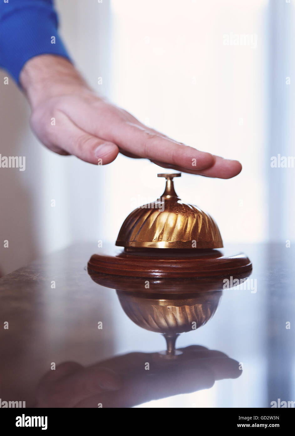 Hand of a man using a hotel bell in retro style Stock Photo