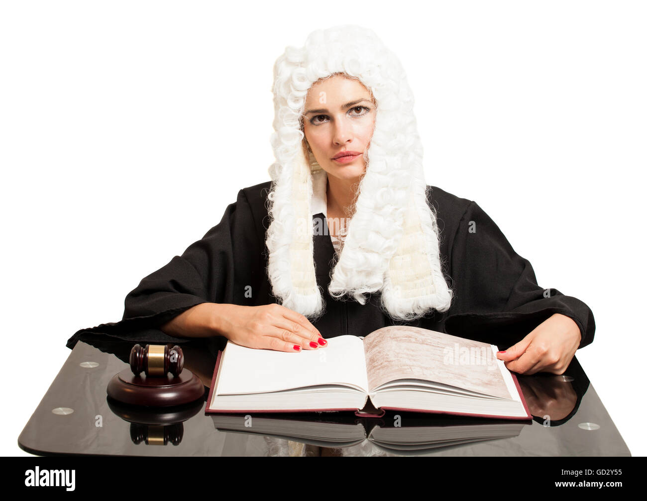 Female judge wearing a wig and black mantle with judge gavel and book