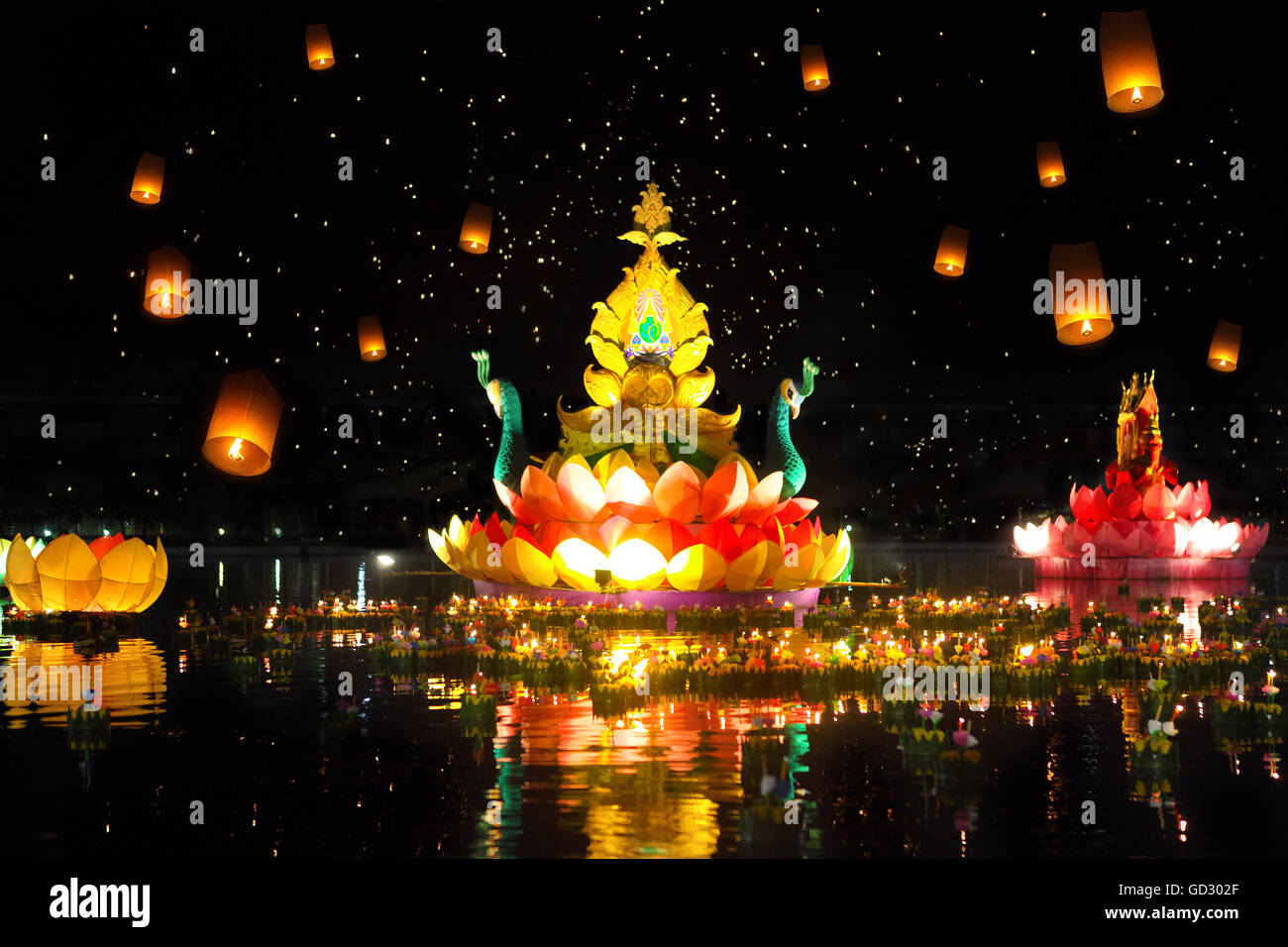 Big and small boats with candles and flowers are given for Thailands traditional Loy Krathong Festival. Sky lanterns in the sky Stock Photo