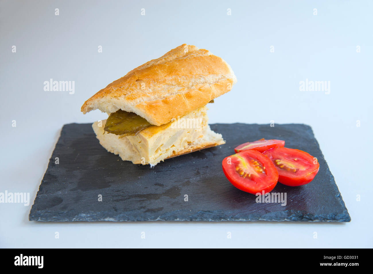 Sandwich made of Spanish omelet and pepper with cherry tomatoes. Stock Photo