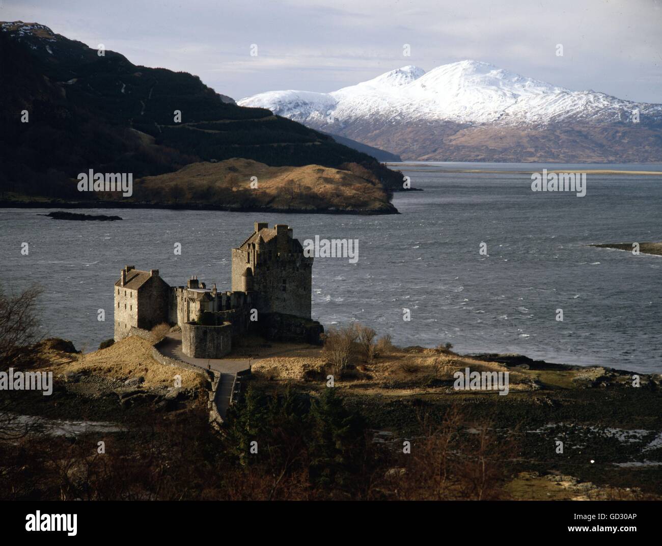 Scotland, Skye. Loch Alsh with Eilean Donan Castle. The snow-covered hills on Skye lie close to KyleRea. Circa 1982.    Scanned Stock Photo