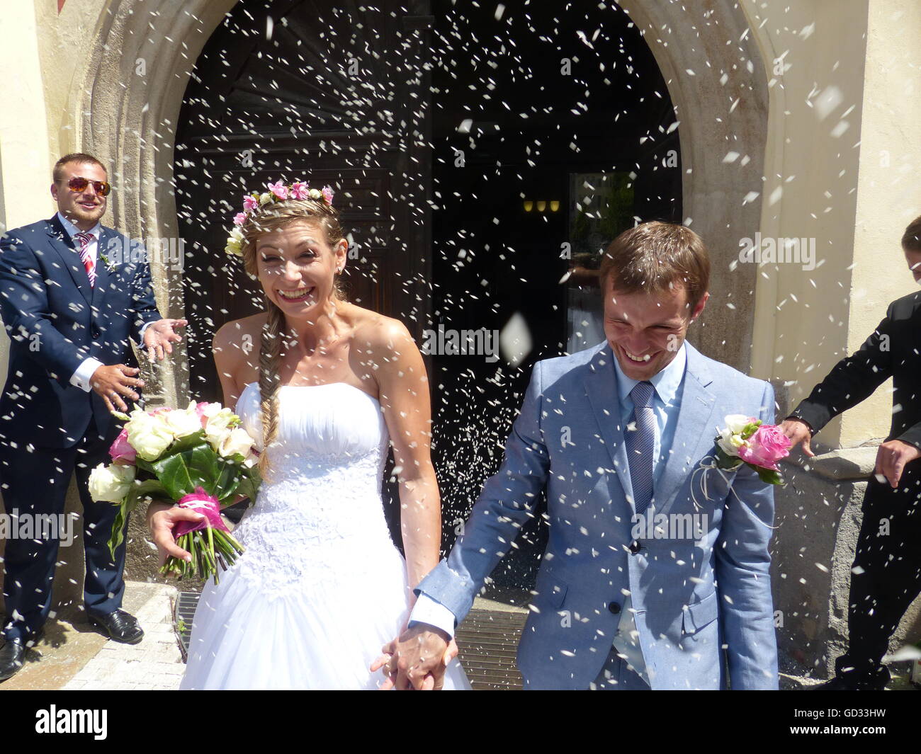 Traditional rice throwing at newlyweds takes place after married couple leaves ceremony Stock Photo