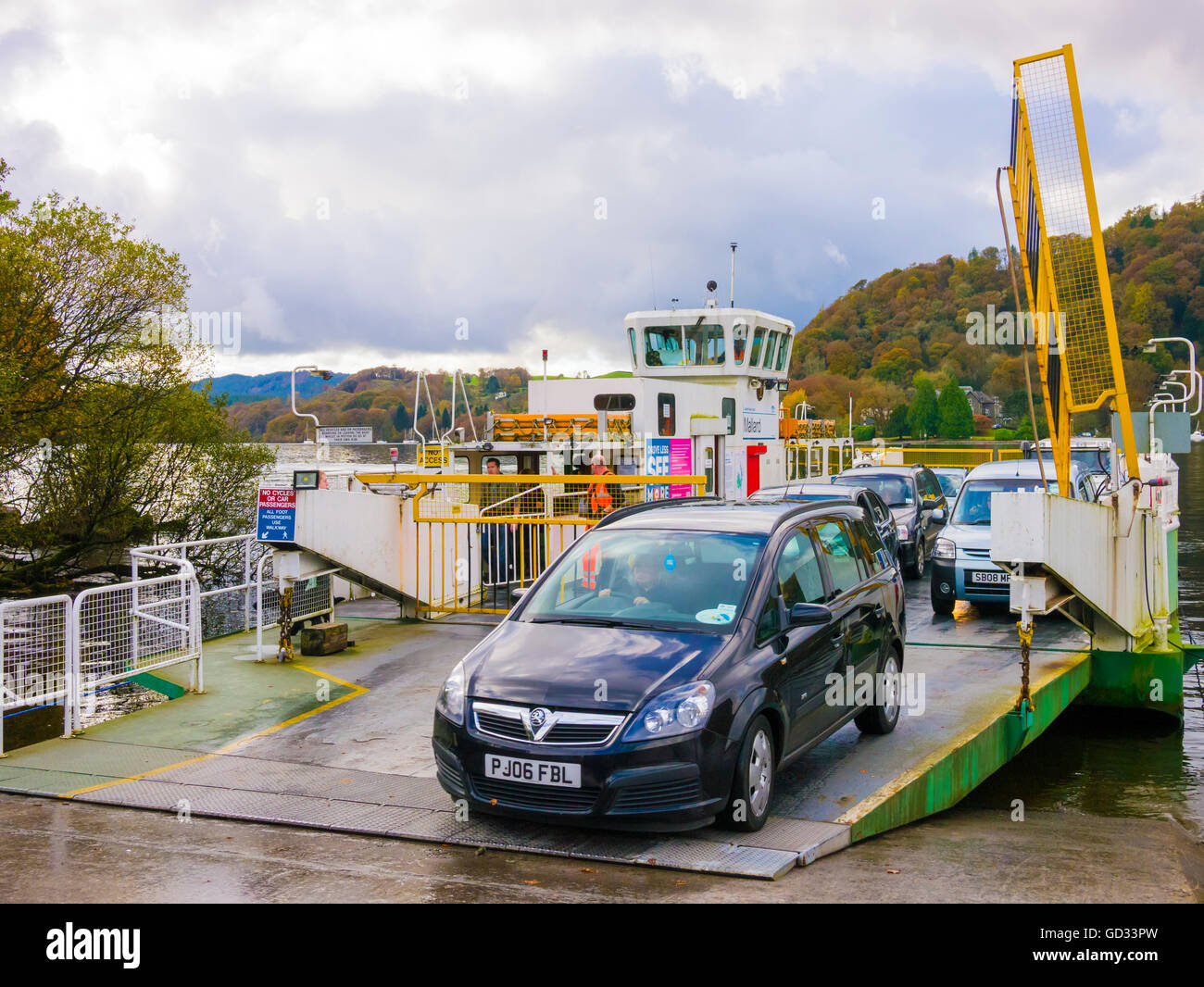 Cars disembarking from the cable operated Windermere ferry at Bowness-on-Windermere in the Lake District, Cumbria, England. Stock Photo