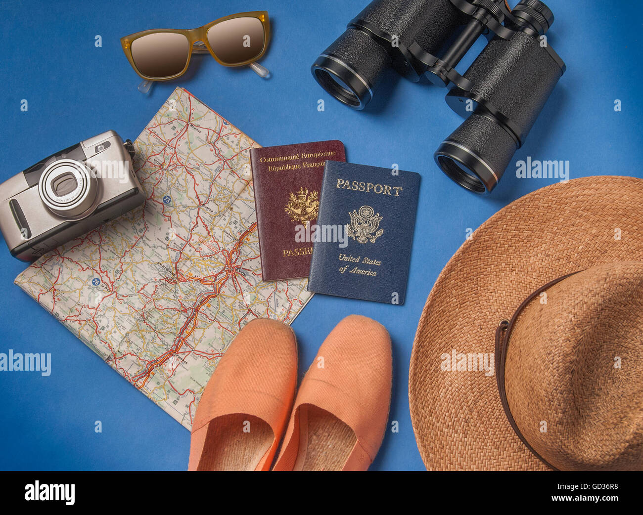 summer vacation, tourism and objects concept - close up of clothes, camera, binoculars, passports and travel map Stock Photo