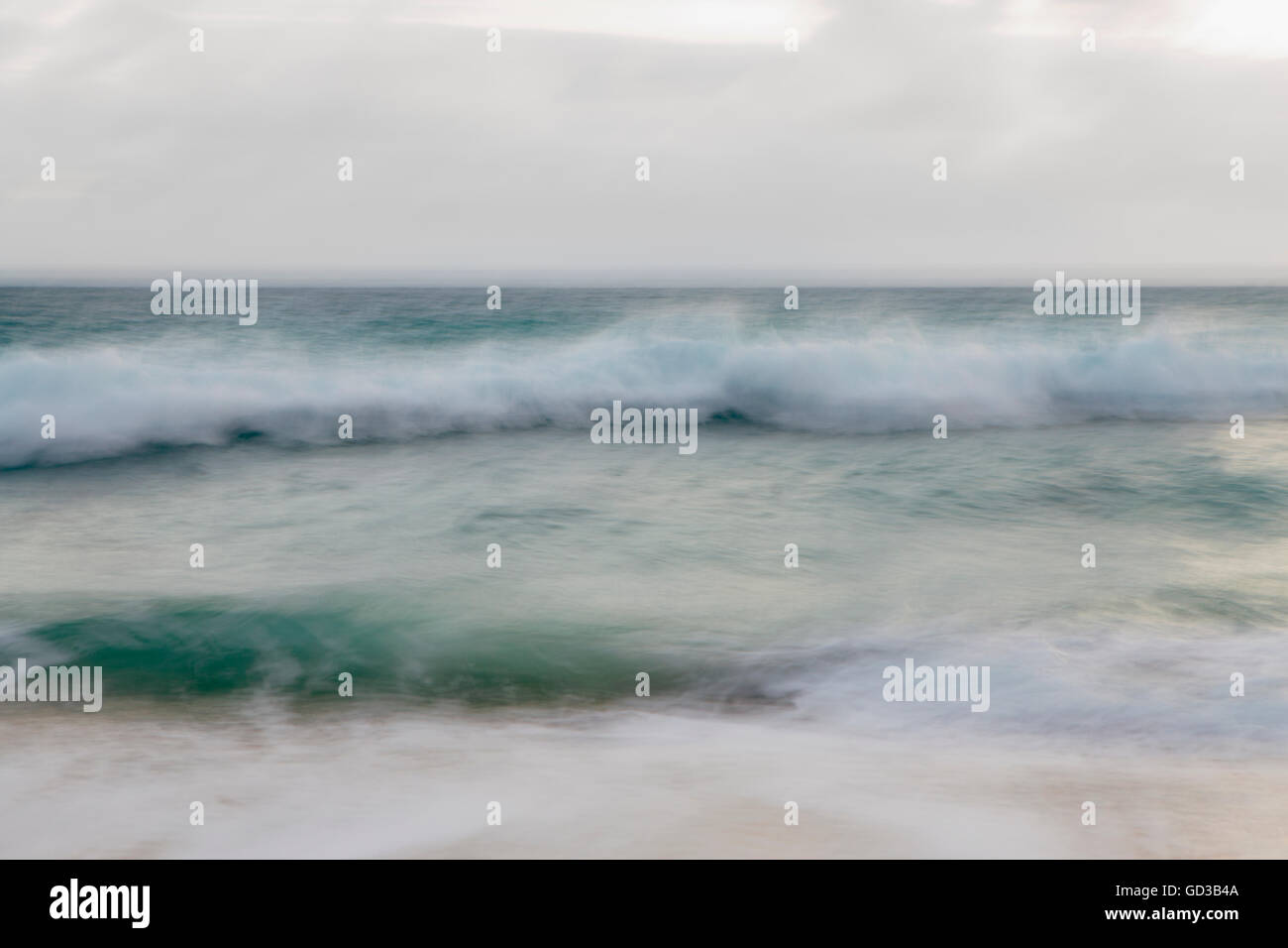 Breaking waves of ocean water and overcast sky. Stock Photo