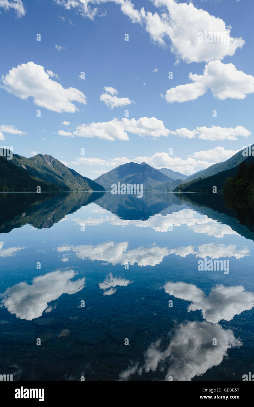 Mirror reflections, the sky and clouds reflected in the surface of the water of Lake Crescent. Stock Photo