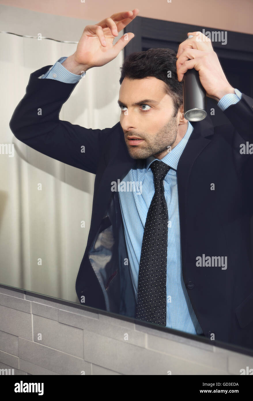 Young handsome businessman makes hair Stock Photo