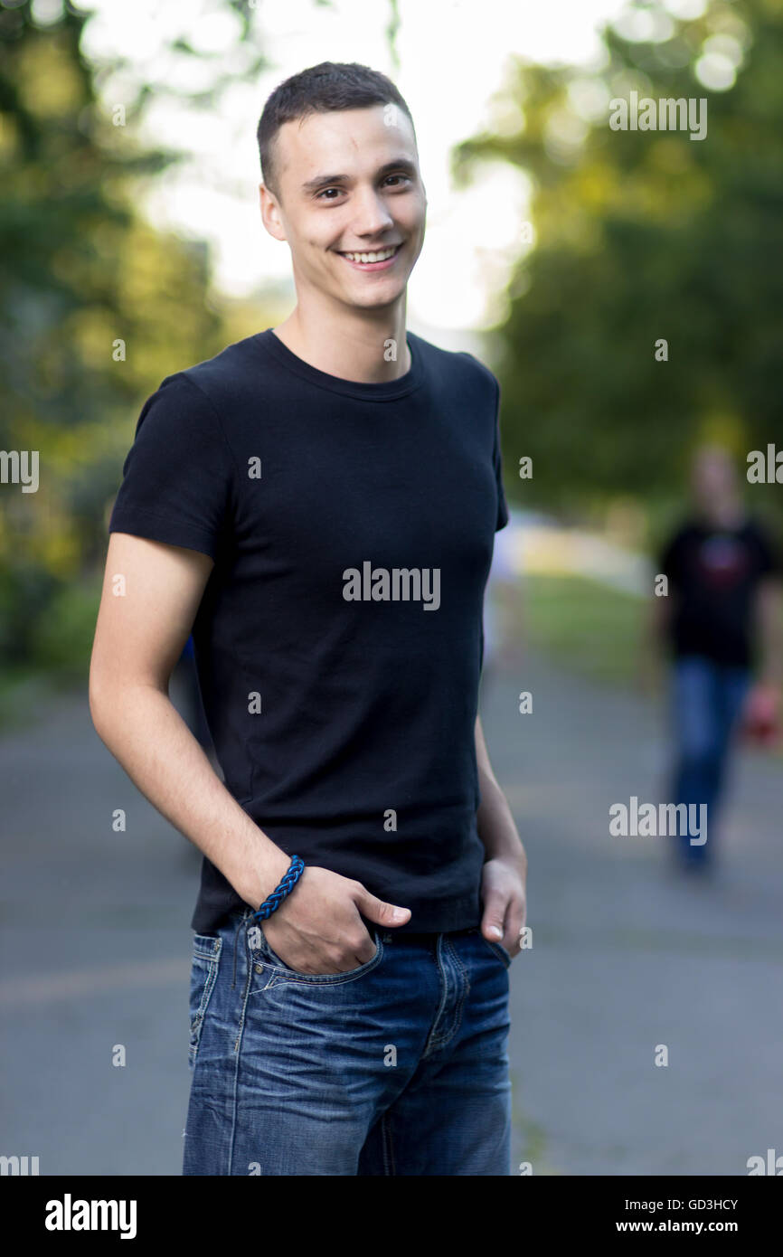 Young Caucasian man in early 20s posing smiling. Shallow depth of field. Stock Photo