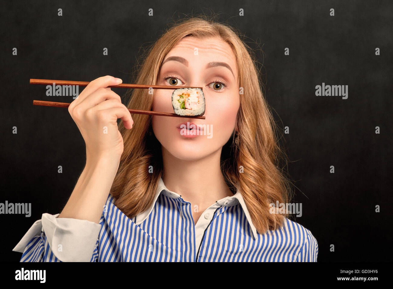 fun girl with sushi roll on black background Stock Photo