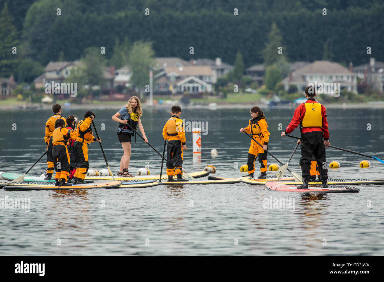 Woman teaching pre-teens and teens how to paddleboard at Lake Sammamish State Park, Issaquah, Washington Stock Photo