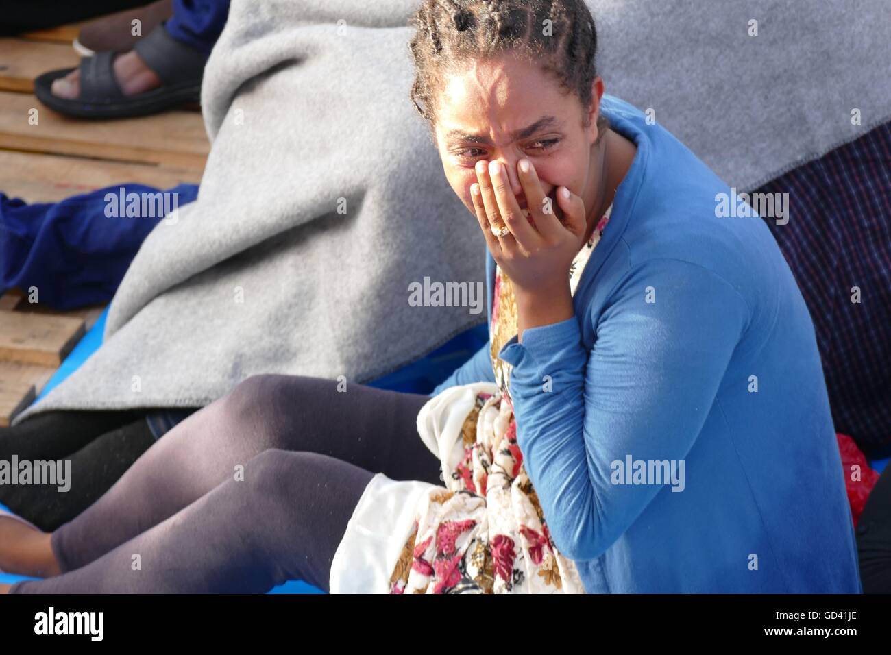 Mediterranean, 17 miles off Libya coast, 12th July, 2016. A humanitarian group recovered the bodies of four migrants and rescued around 400 survivors on Tuesday from an overcrowded wooden boat in the Mediterranean en route to Italy from Libya. The dead suffocated below deck, said the Malta-based Migrant Offshore Aid Station, whose rescue ship carried out the operation. Credit:  Adam Alexander/Alamy Live News Stock Photo