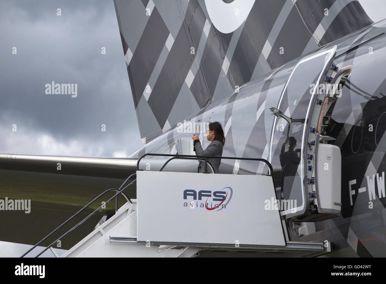 Farnborough, Hampshire, UK. 12th July, 2016. Farnborough International Airshow 2016 Tuesday 12th July 2016. Woman taking a photograph from the steps of a F-WWCF - Airbus A350-941 - Airbus - Flightradar24 Credit:  Jeff Gilbert/Alamy Live News Stock Photo