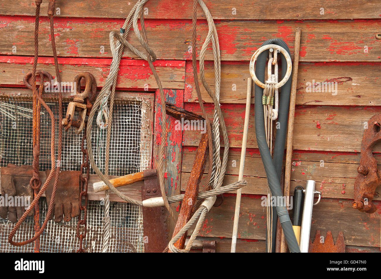 Tool wall on a fishing boat contains great variety of old school tools, covered in rust, but still working Stock Photo