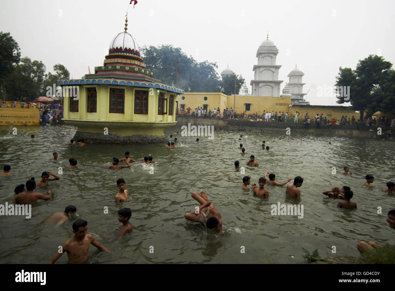 Devotees taking dip in holy pound at historical temple Stock Photo