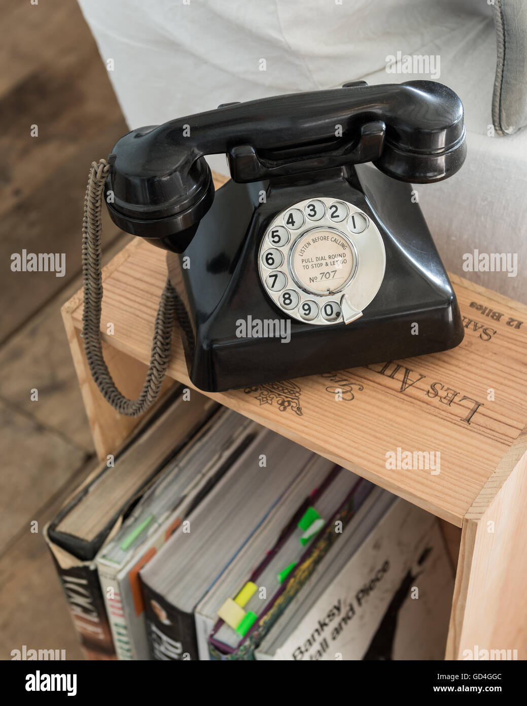 Bakelite telephone on wine crate used as side table Stock Photo